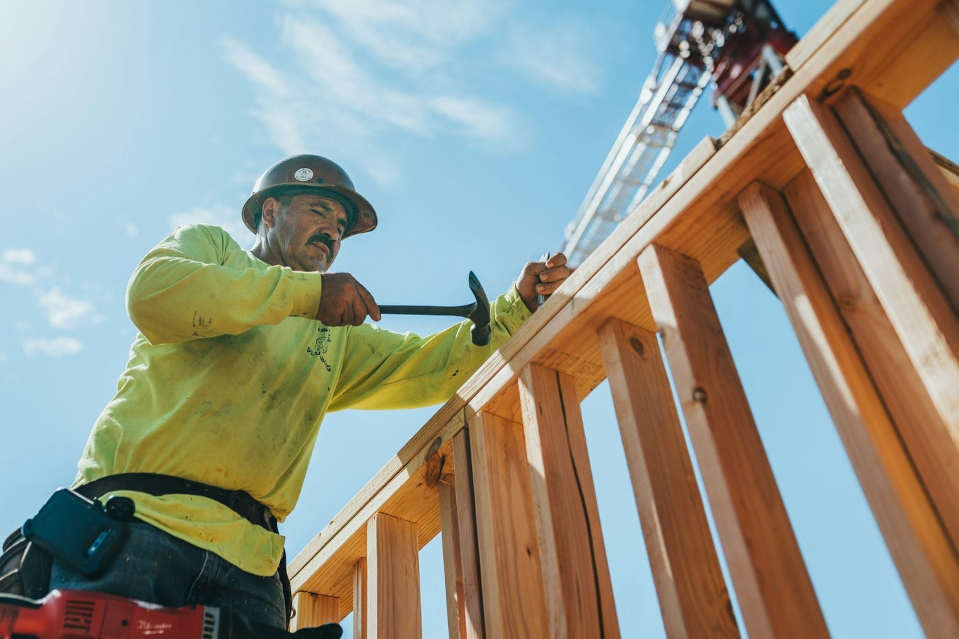 Un charpentier qui monte une charpente de bois sur un chantier