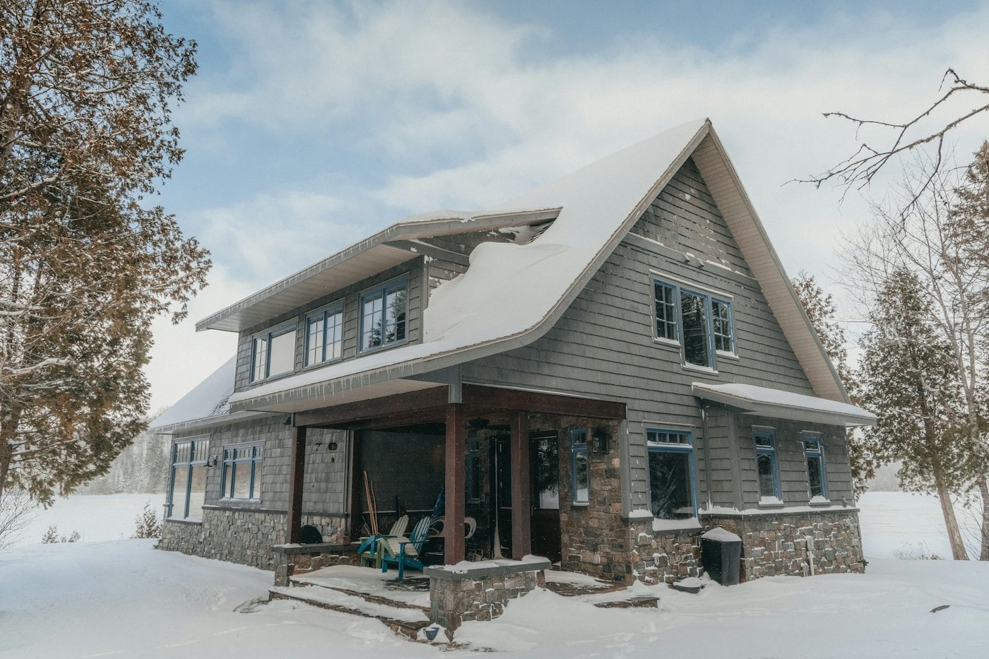 Une maison en hiver, sous la neige, dans les arbres