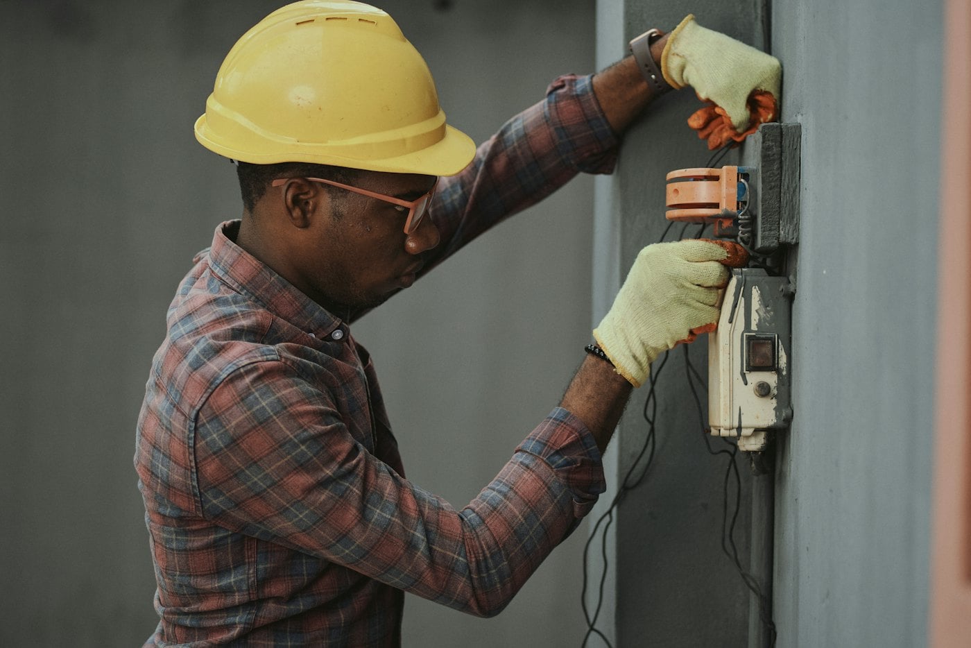 Un électricien qui travaille dans un boîtier de raccordement